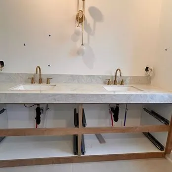 A marble double vanity with brass taps mid rough-in