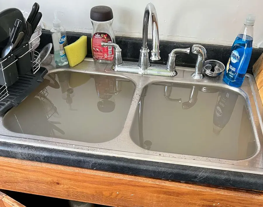 A double kitchen sink backed up and full of standing water